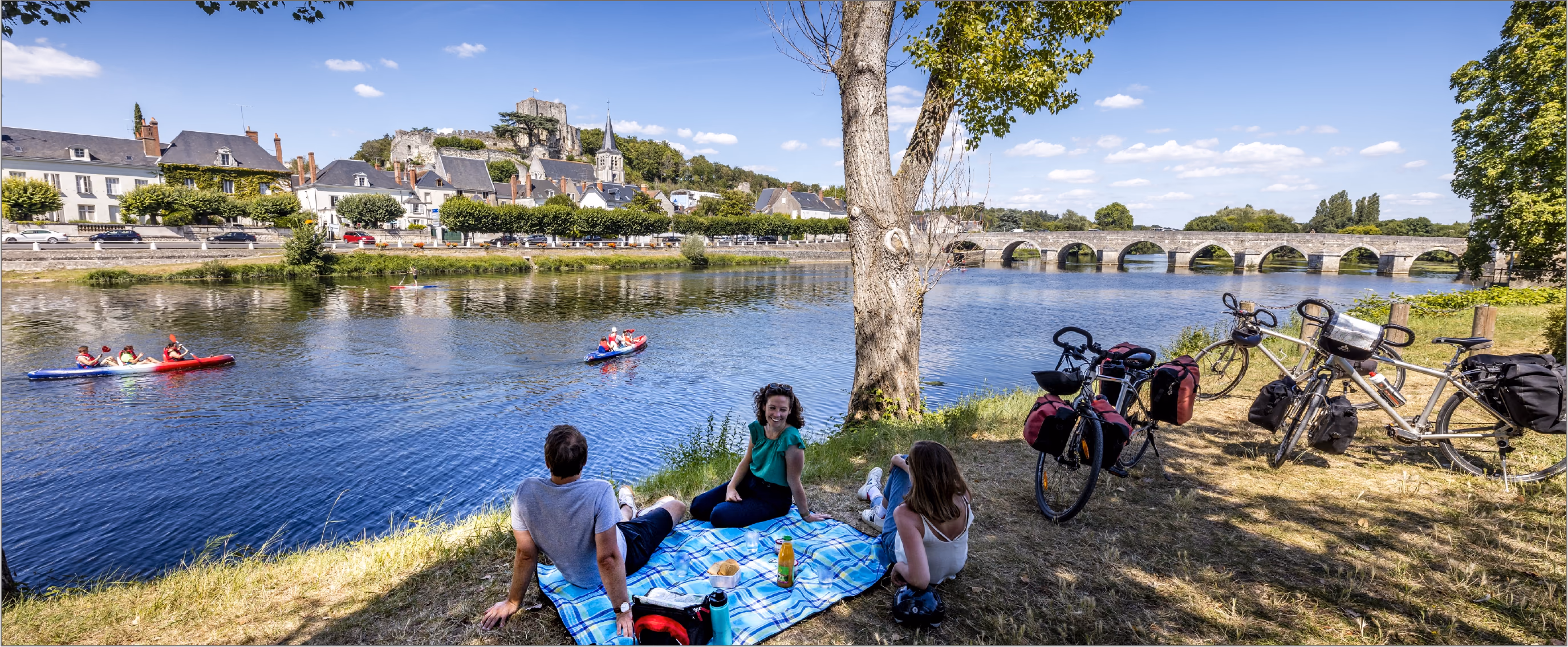 Pique-nique et vélos au bord de la Loire face à Amboise, château et pont en arrière-plan